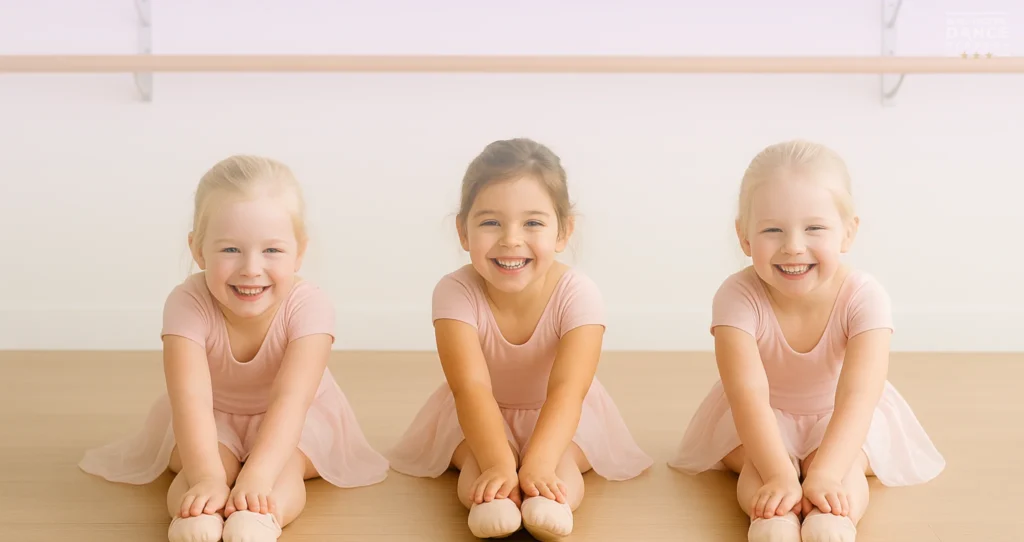 Girls in ballet class stretching on floor with arms out like airplanes.